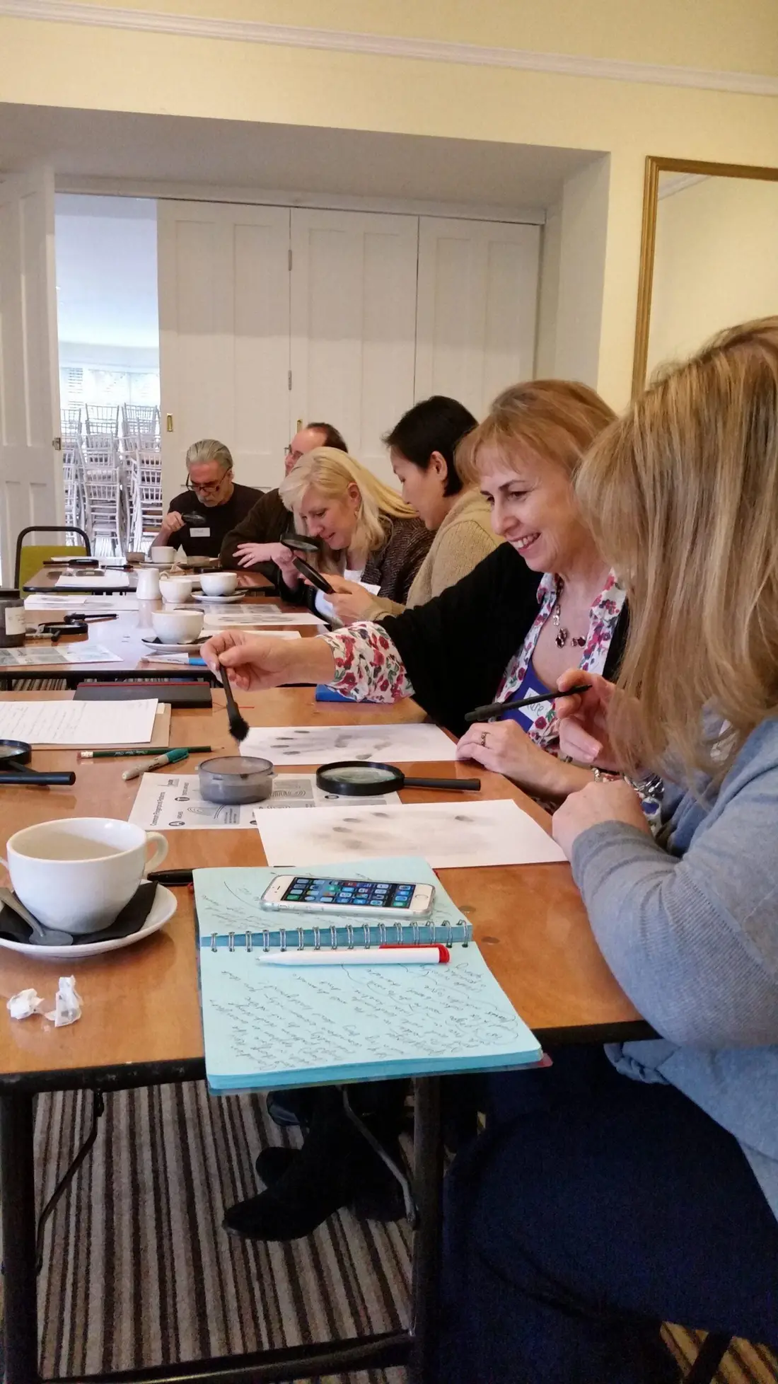 Colleagues at long tables reading their murder mystery scripts