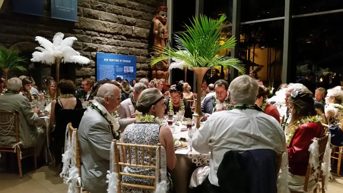 Guests in 1920s costume at dinner tables during a murder mystery evening