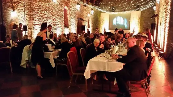 A candlelit banqueting hall full of diners at an Agatha Christie festival murder mystery