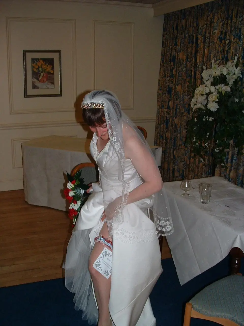 A bride lifting her dress as she walks through the reception room