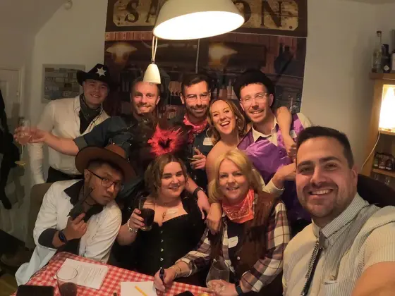 A group in fancy dress taking a selfie at a murder mystery party