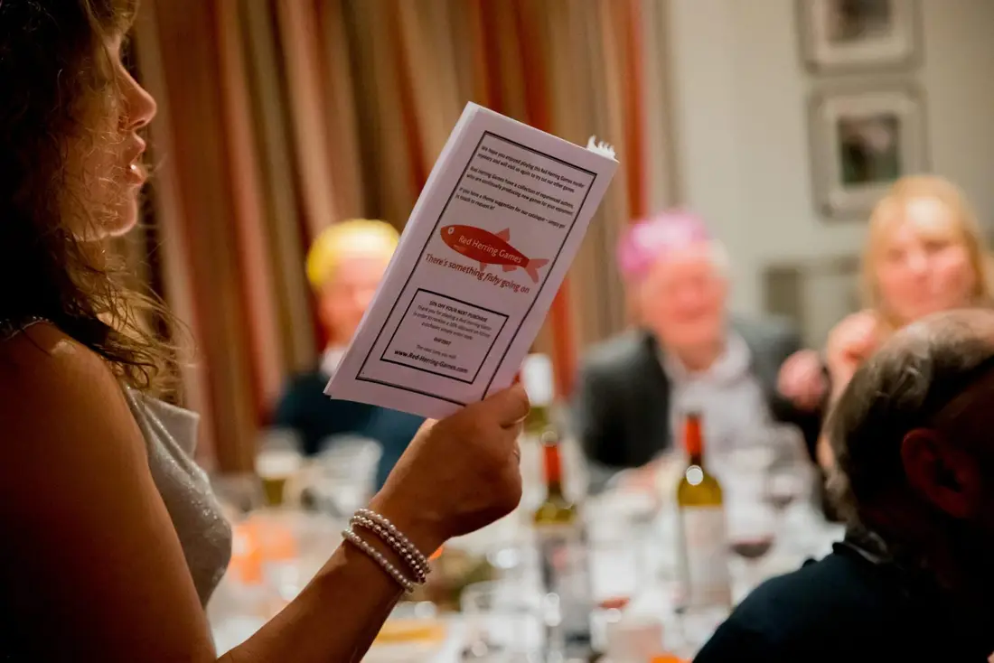 A guest reading her character booklet at a dinner table
