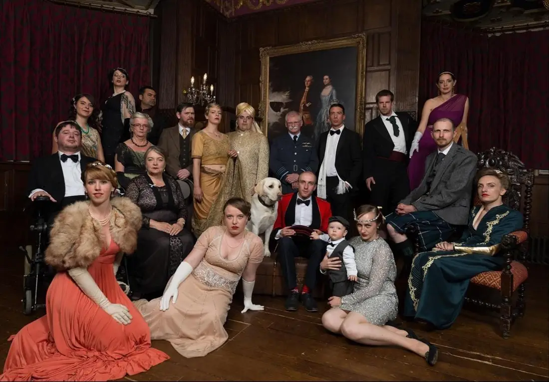 A murder mystery cast in 1920s costume, posed together in a panelled room