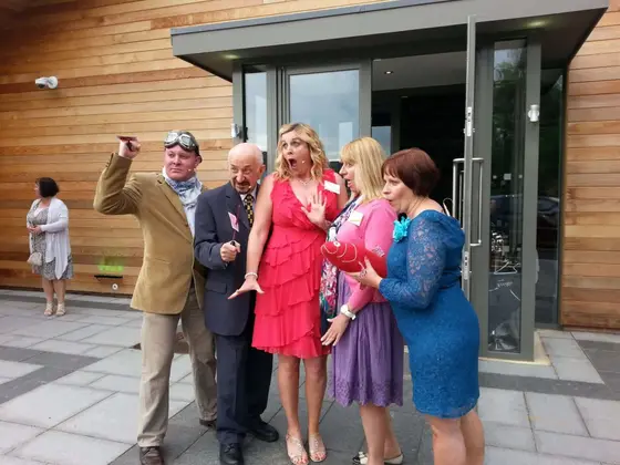 Actors in costume reacting to a discovery outside a hotel