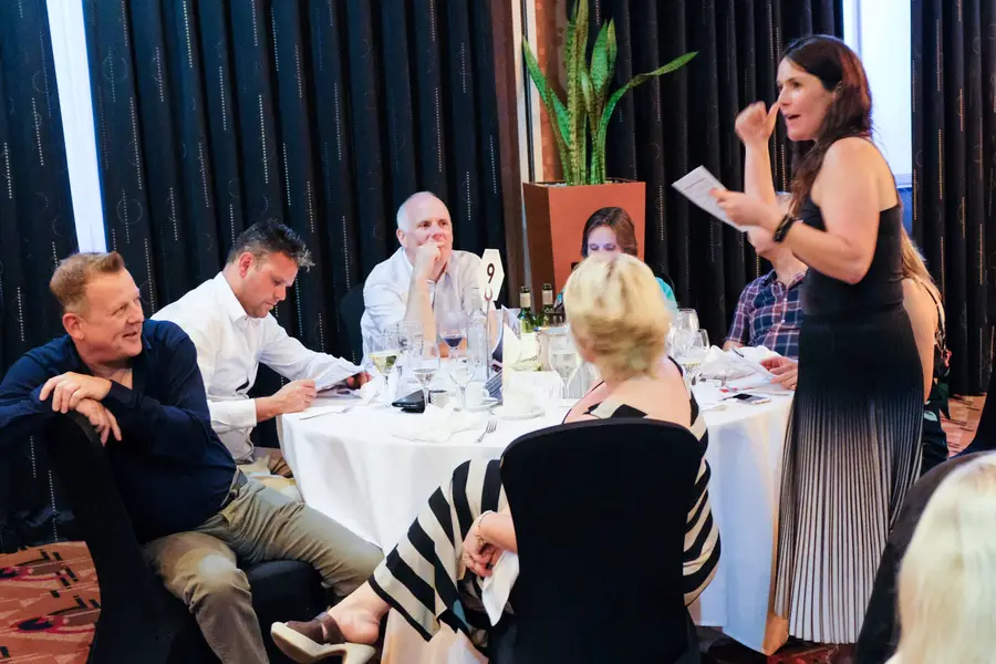 A Red Herring Games actor performing a murder mystery to seated guests
